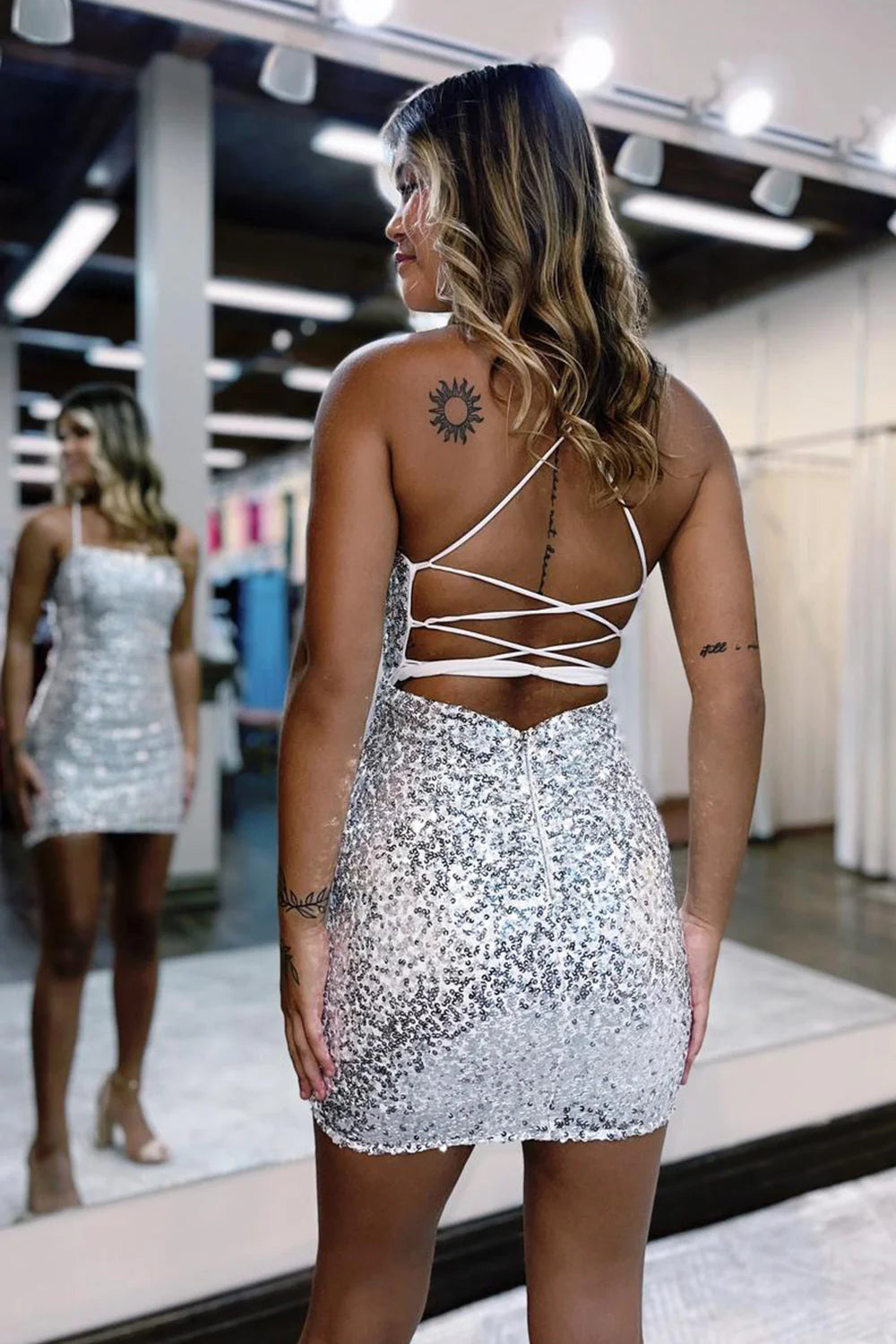 Model posing in the sparkly sequined V-neck short homecoming dress, side view.