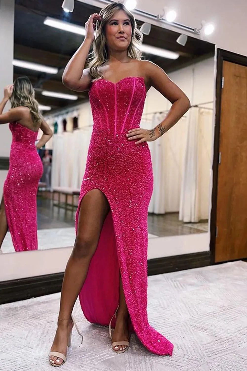 Model wearing a dazzling sheath sweetheart sequin floor length prom dress with a split front.