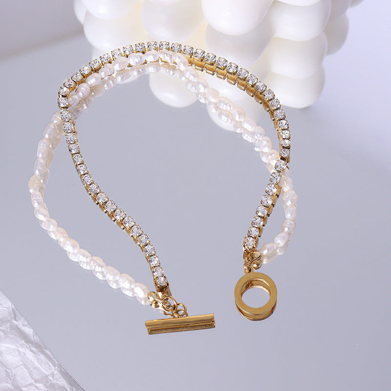 Double-layered chain bracelet with freshwater pearls and zircon on a wrist.