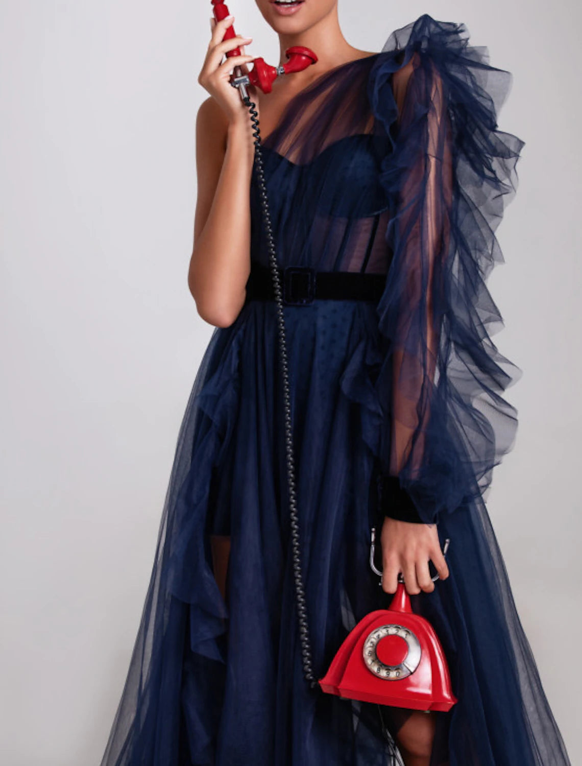 Side view of the one-shoulder long sleeve evening gown with structured corset bodice.