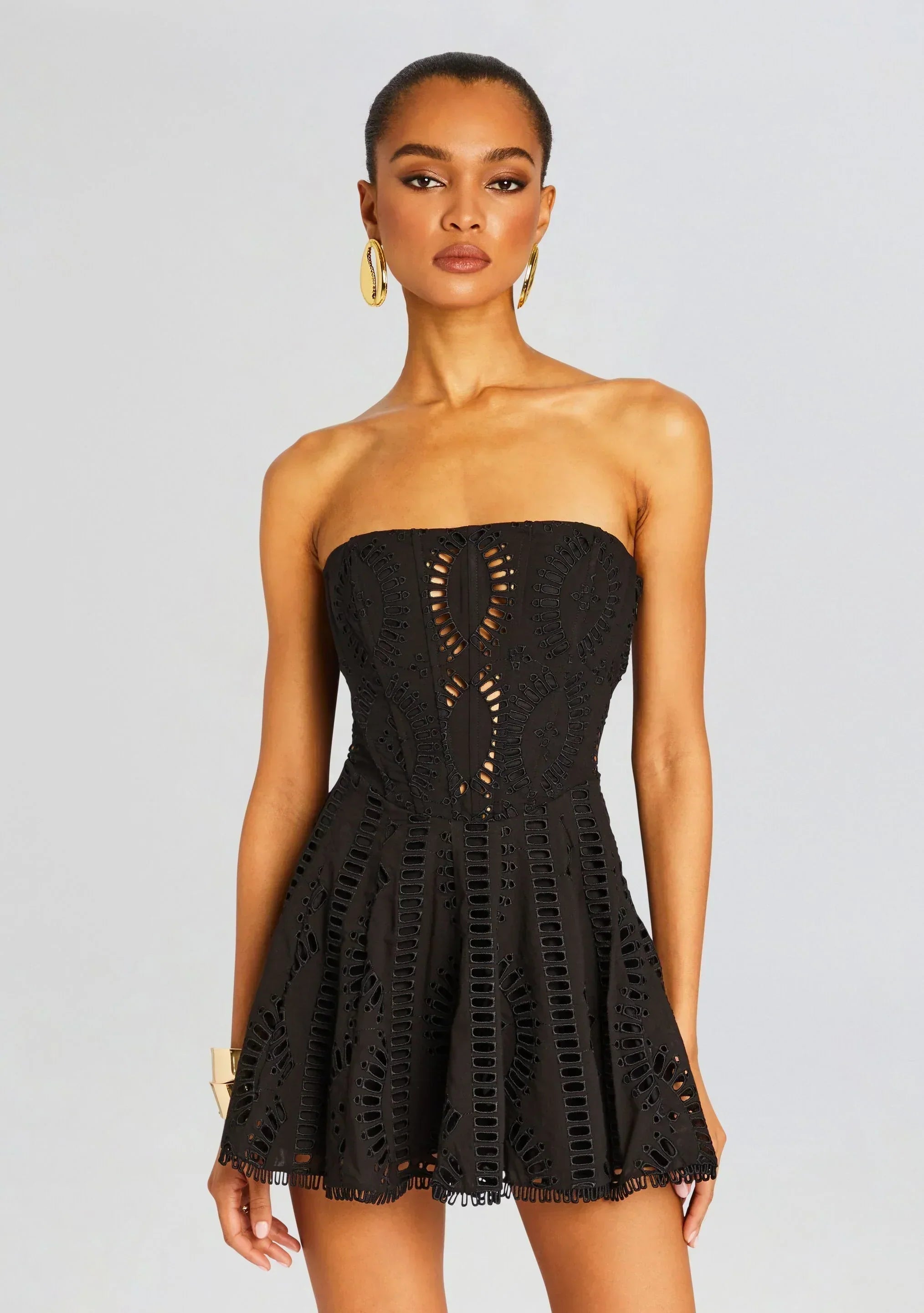 Black strapless laser cutout A-line mini homecoming dress, side view.
