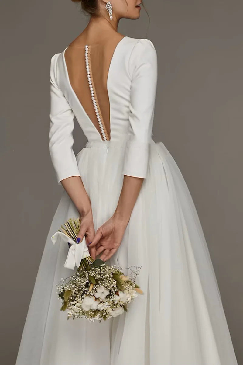 Full view of a white vintage-style tea length bridal gown with 3/4 sleeves.