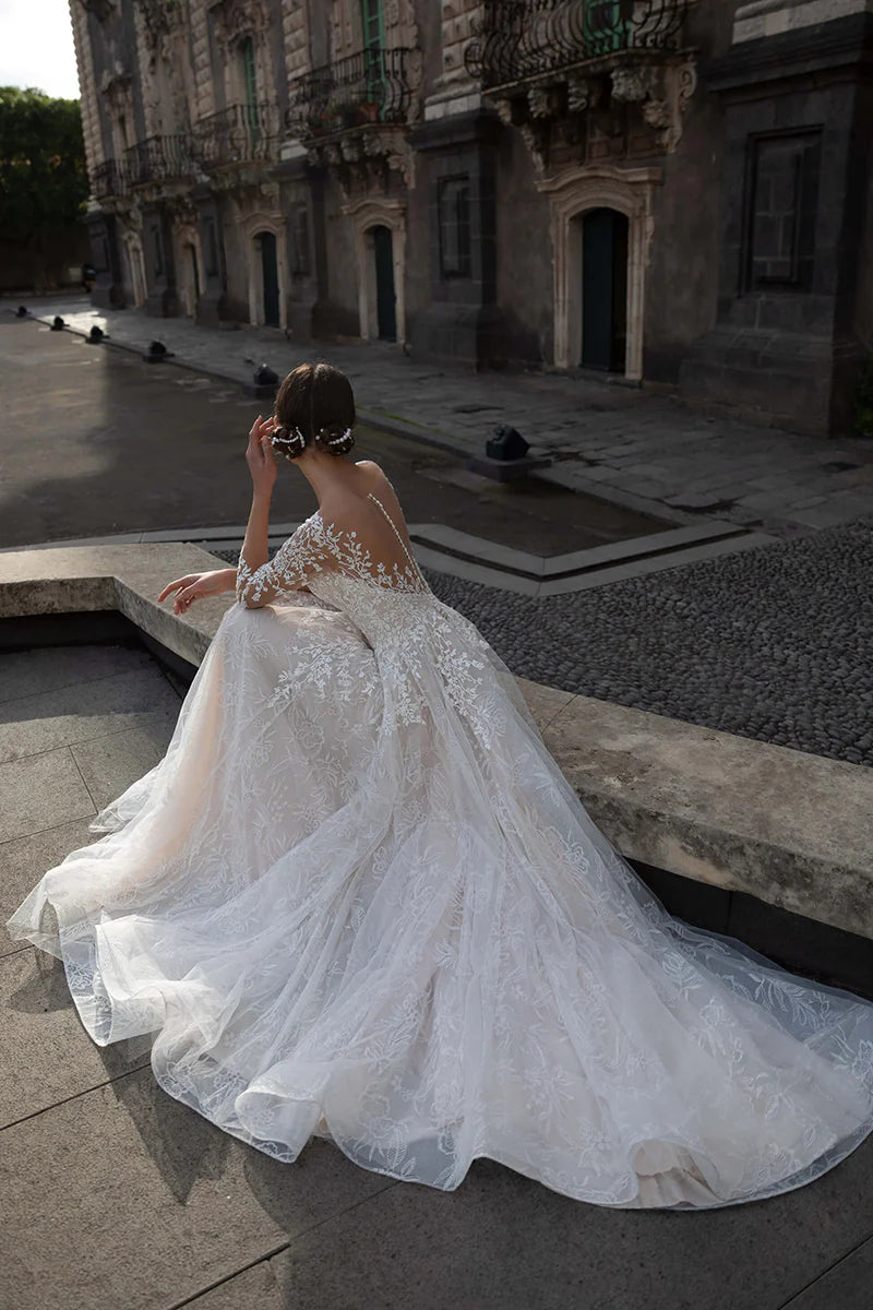 Close-up of the long lace sleeves and Bardot neckline on the A-line wedding dress.
