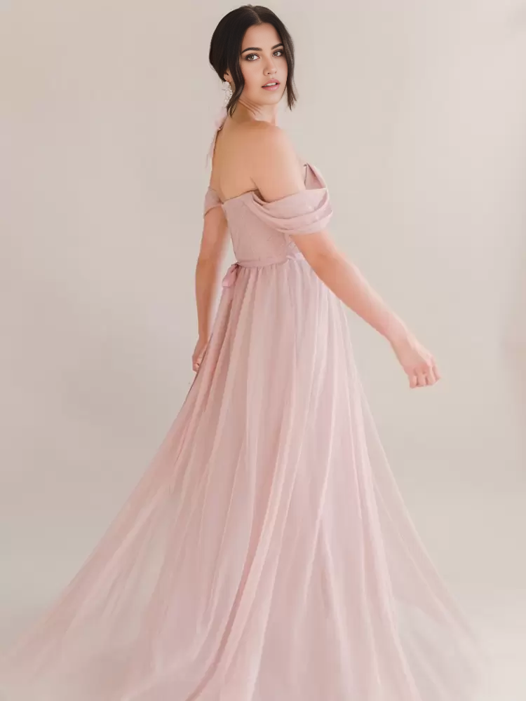 Side view of a woman in a pleated A-line chiffon evening dress.