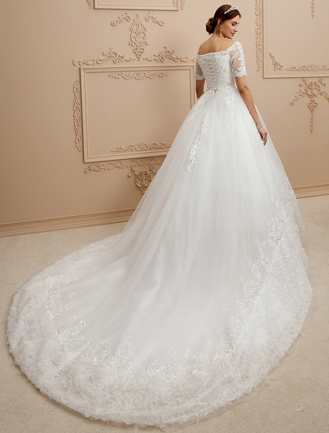 Side view of an A-Line wedding dress showing the flowing tulle skirt and cathedral train.