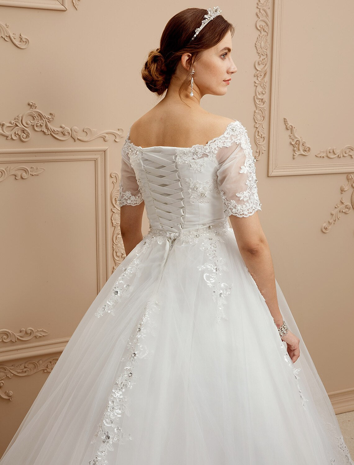 Bride posing in an A-Line wedding dress with a bateau neckline and elegant silhouette.