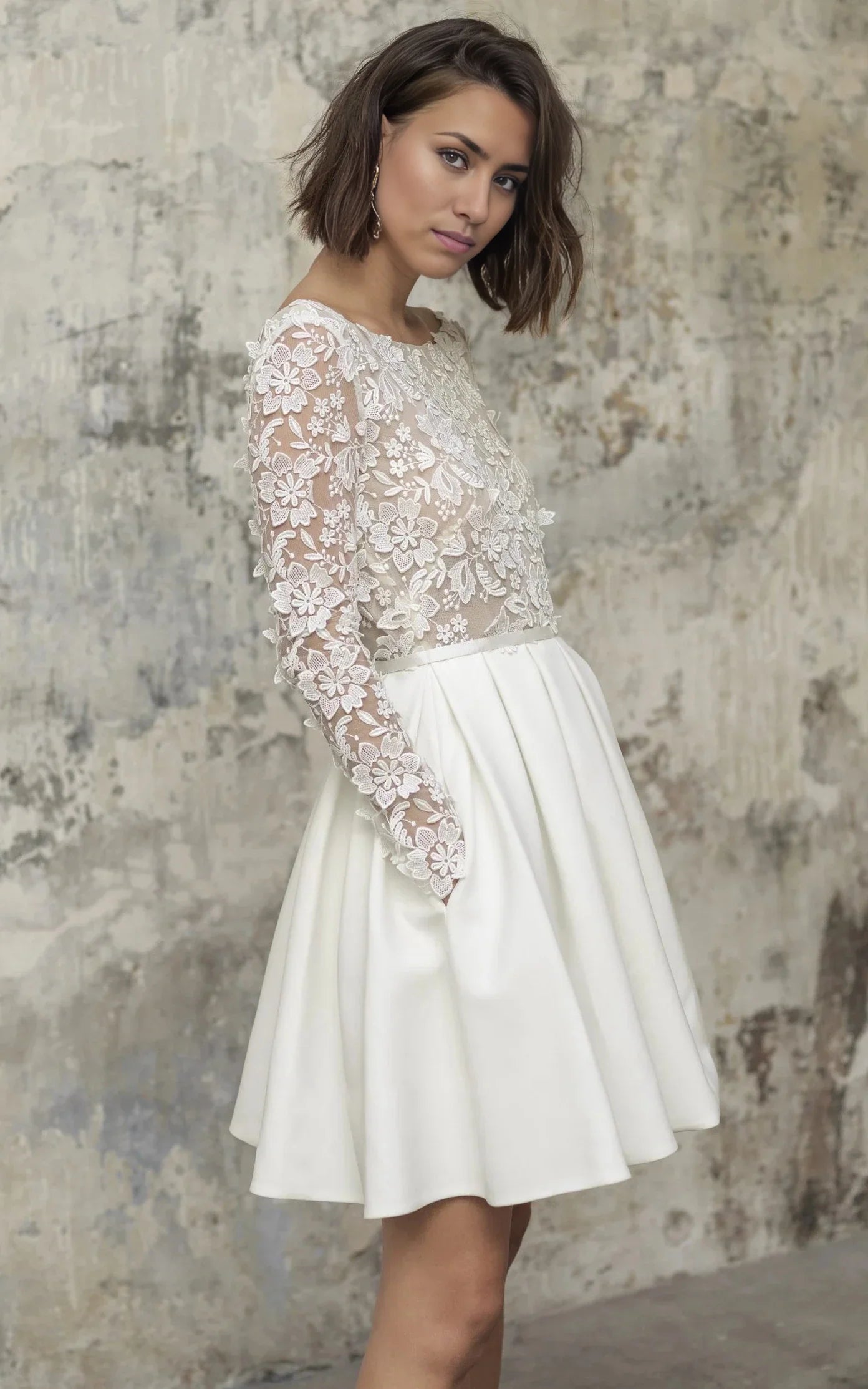 Elegant A-line knee-length wedding dress with long sleeves and bateau neckline.