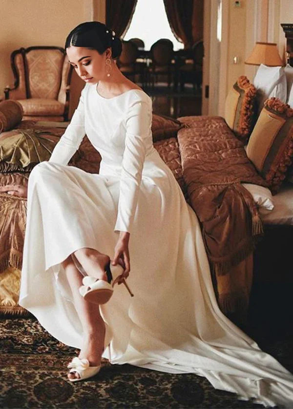 A-line wedding dress with bateau neckline and long sleeves.