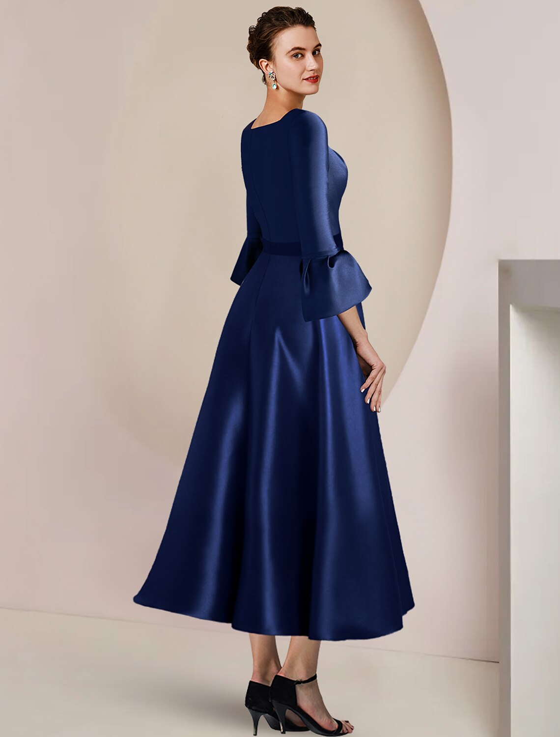 Side view of the satin A-Line dress, showcasing 3/4 sleeves and flowing skirt.