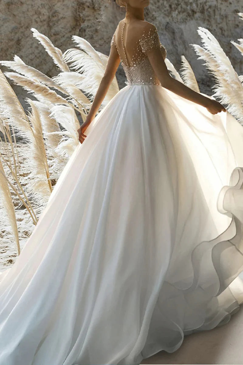 Back view of an A-line beaded short sleeve wedding dress.