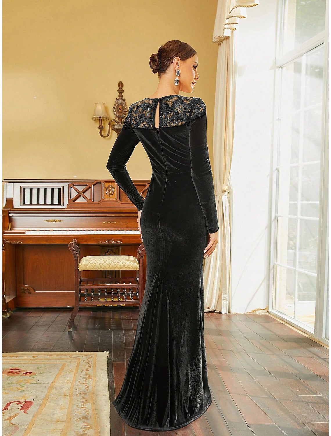 Side view of black velvet A-line gown, showing long sleeves and sweep train.