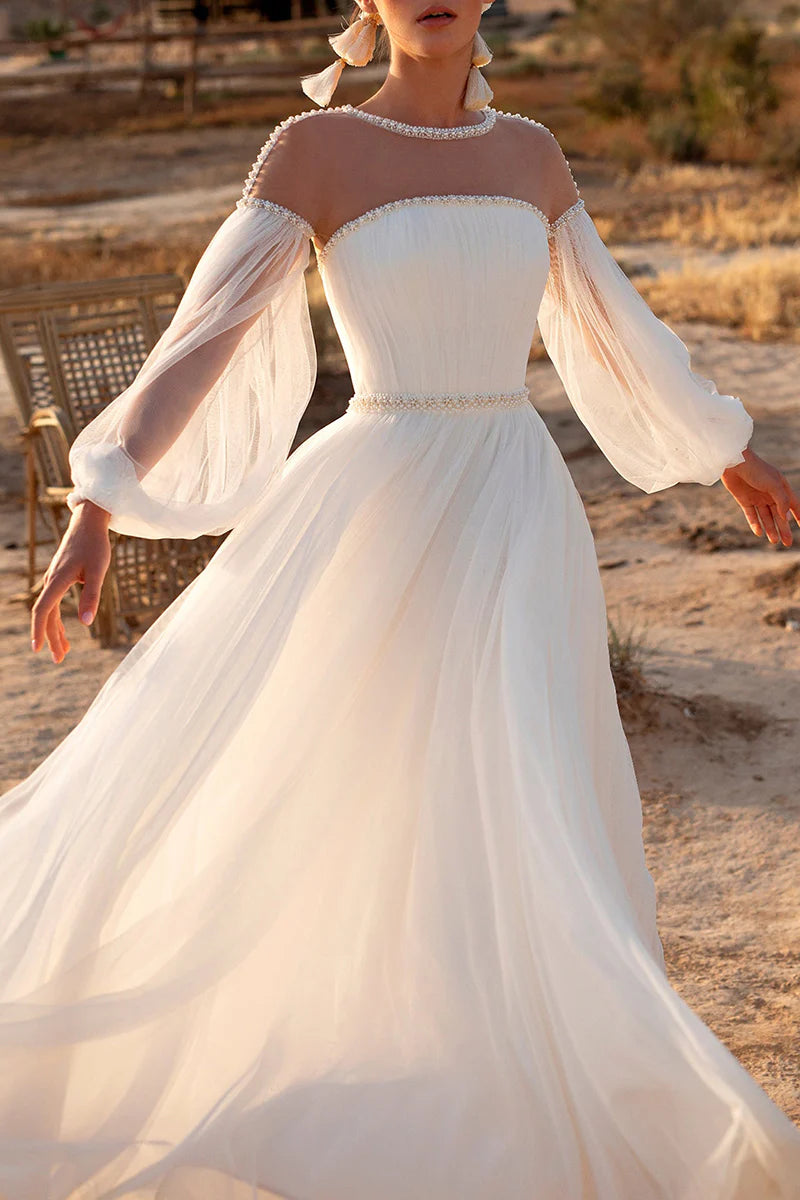 Full view of an elegant A-line wedding dress with a boat neck, long sleeves, and pearl details.