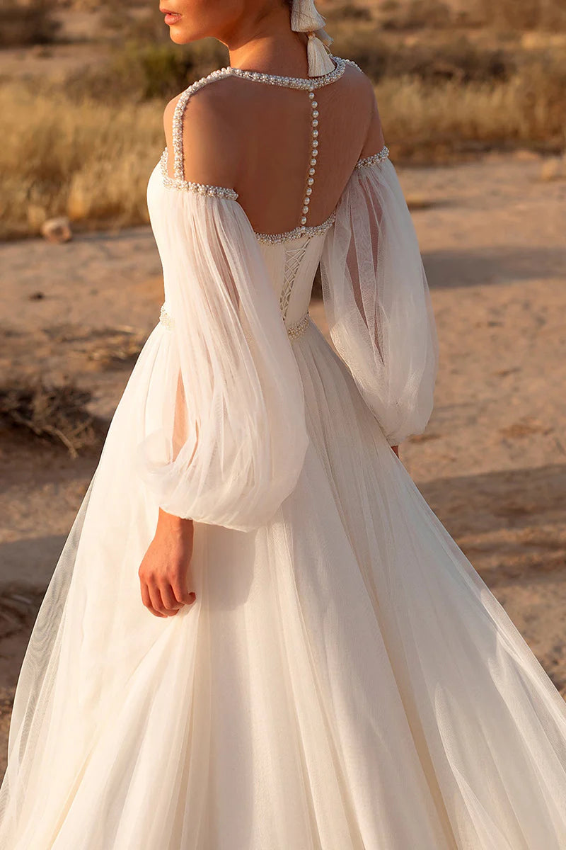 Side view of the A-line wedding dress, showcasing the flowing skirt and long sleeves.