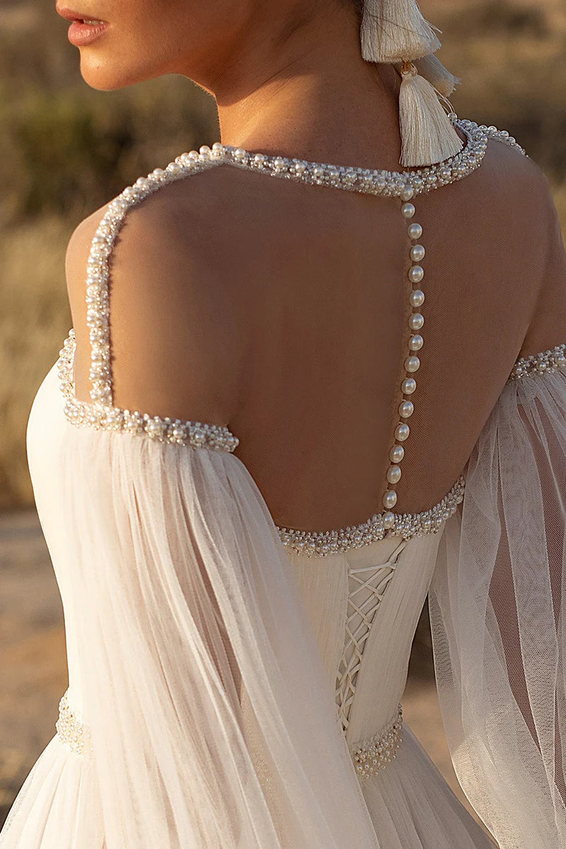 Detail of the long sleeves and fabric texture of the bridal gown.