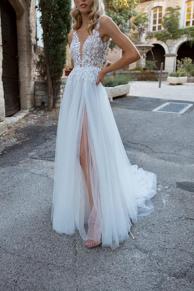 Model wearing an A-line boho V-neck wedding dress with lace appliques.