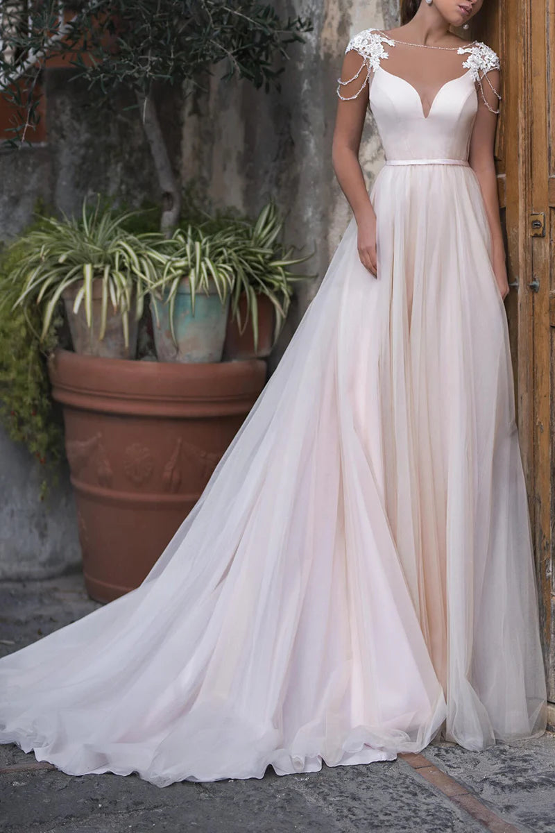 Model wearing an elegant A-line boho wedding dress with a boat neckline and appliques.