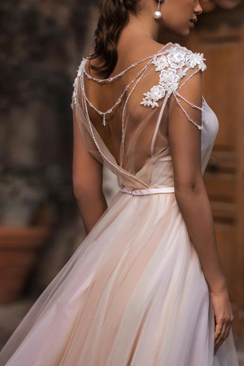 Close-up of the appliques and boat neckline detail on an A-line boho wedding dress.