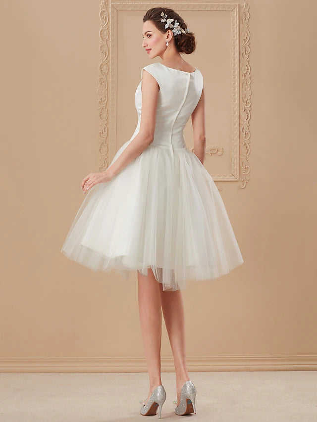 Elegant white knee-length wedding dress ideal for a beach ceremony.