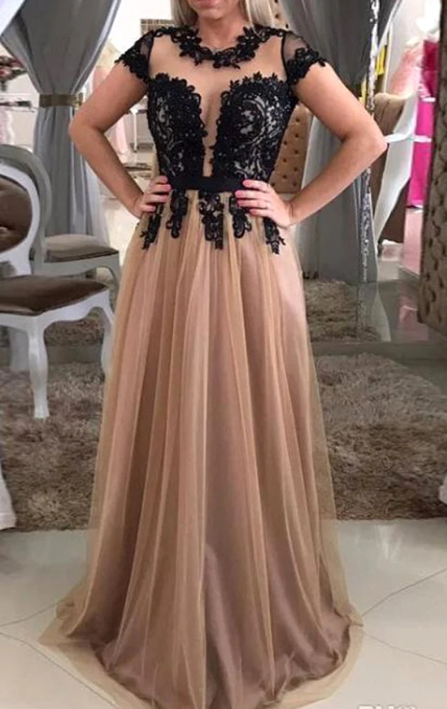 Woman wearing an elegant long prom dress with cap sleeves, lace bodice, and tulle skirt.