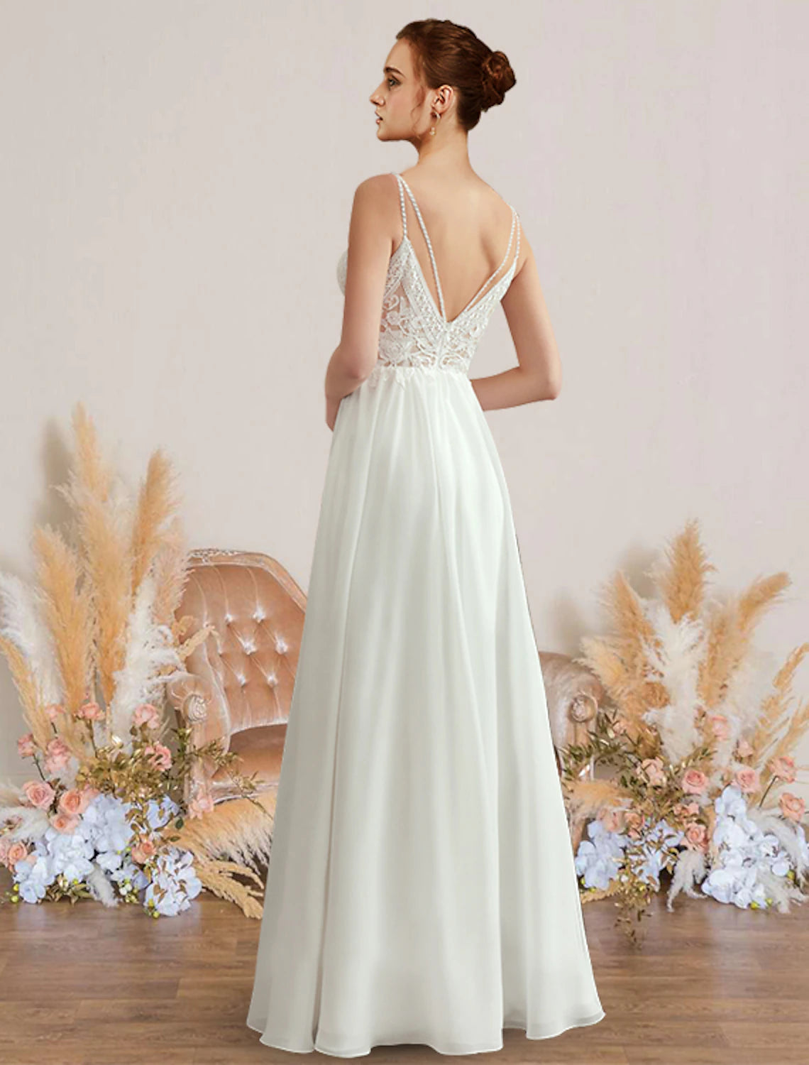 Back view of an A-line chiffon wedding dress featuring delicate appliques and a flowing skirt.