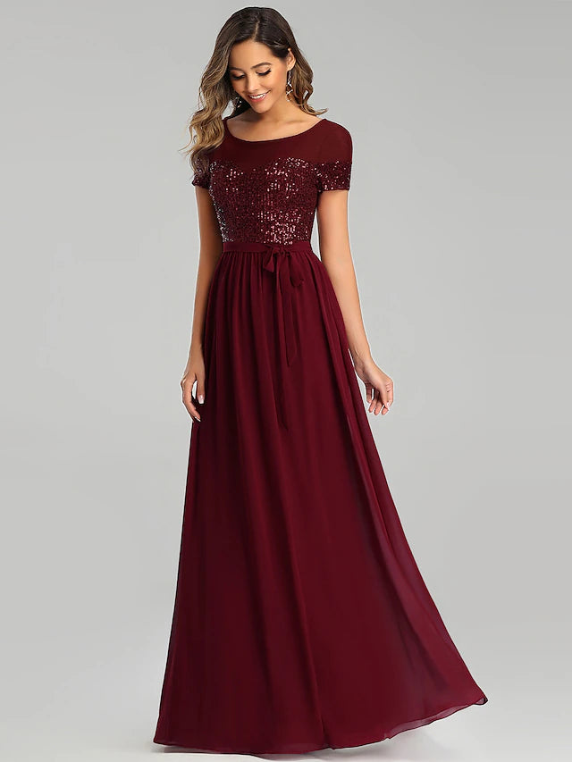 Close-up of the jewel neck and short sleeve detail on the chiffon dress.