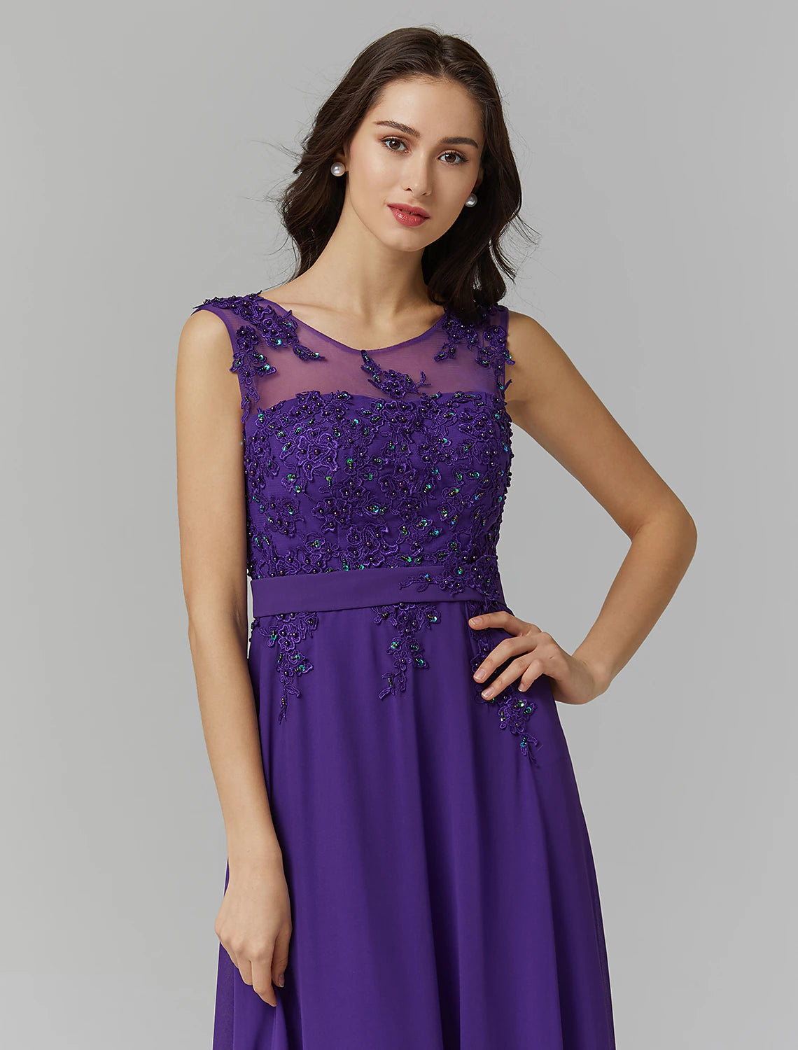 Model posing in a sleeveless A-line dress, suitable for formal events.