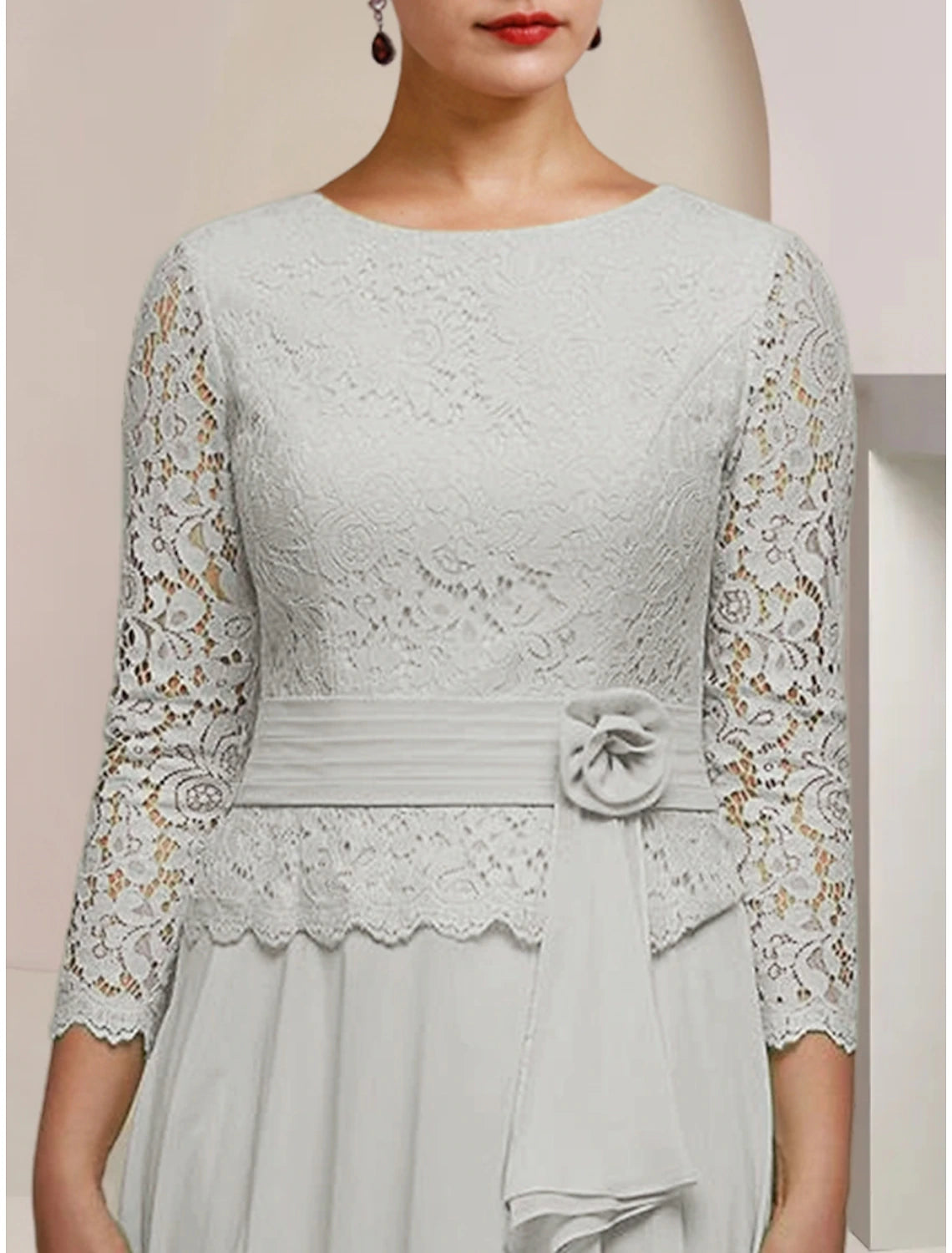 Detail of lace appliques and pleats on the elegant formal dress.