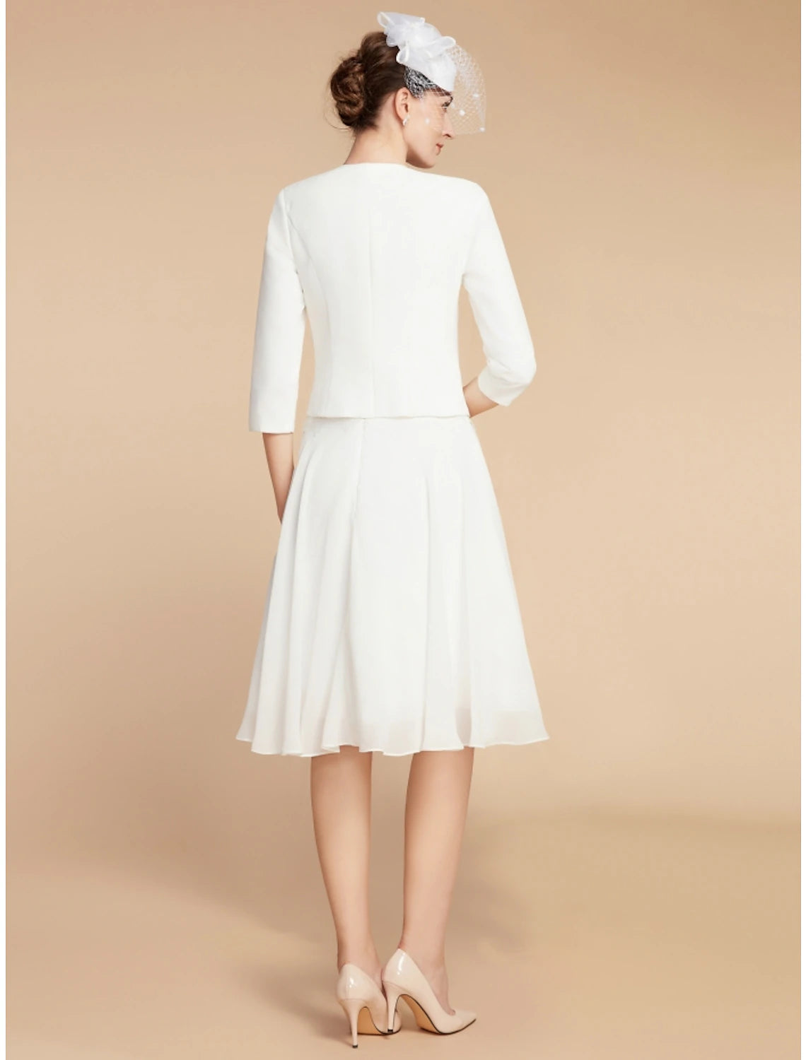 Back view of the two-piece knee-length dress, showing solid color.
