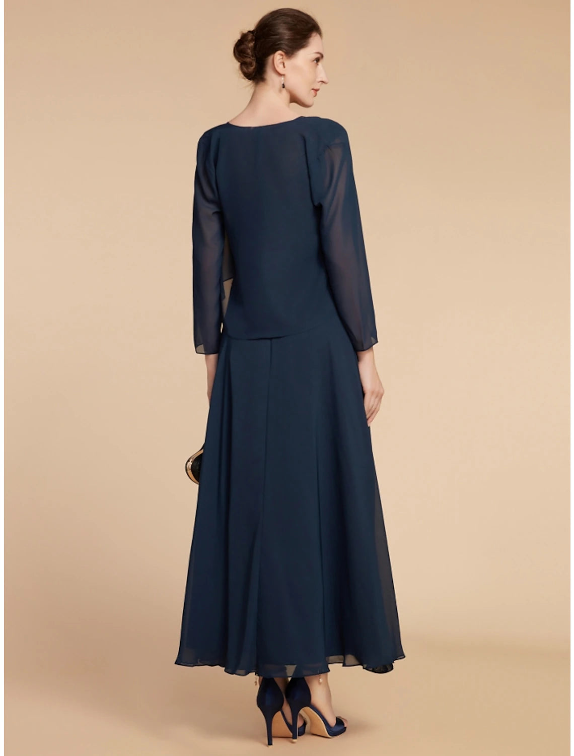 Back view of an A-line navy blue formal dress, showing the delicate lace and ruching details.