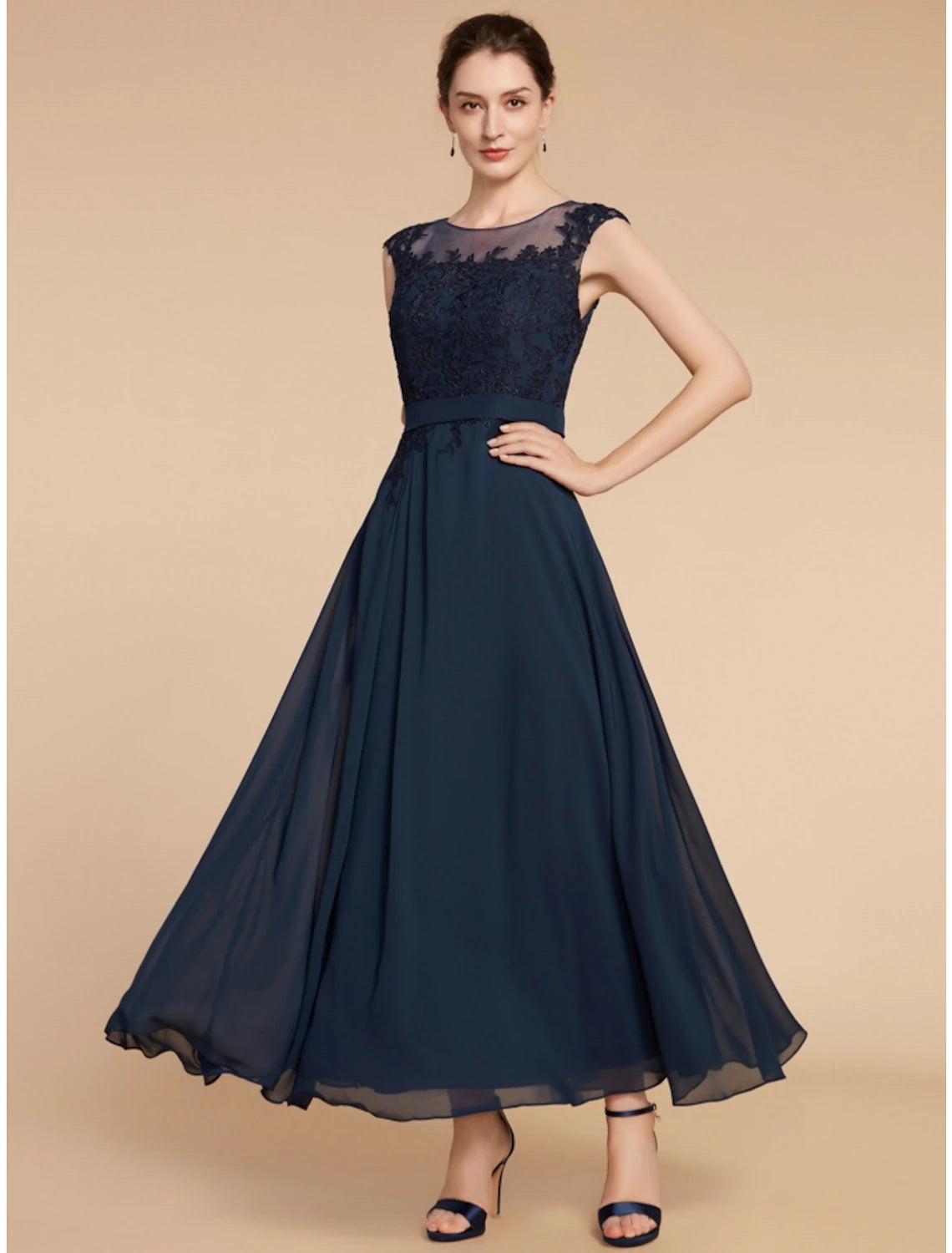 Side view of a woman in a navy blue chiffon lace gown, highlighting the ankle length and flowing silhouette.