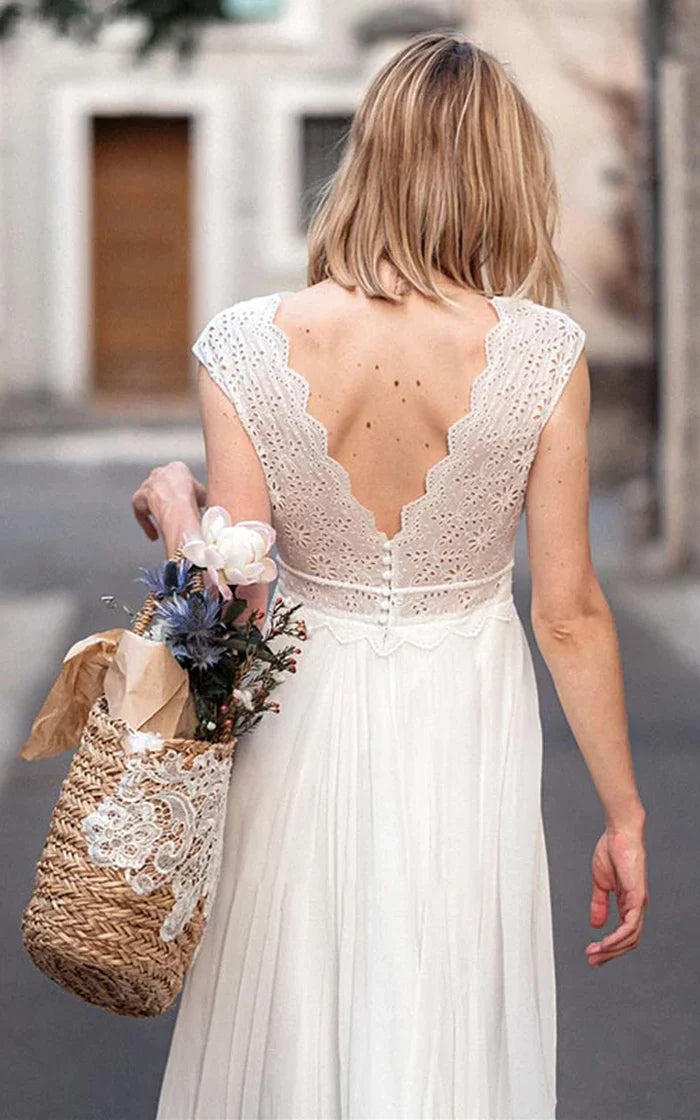 Side profile of a bride wearing a short sleeve lace and chiffon wedding gown.