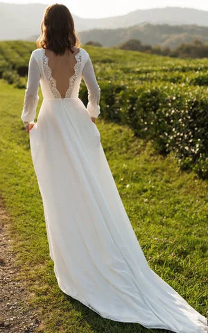 Side view of a bride wearing an A-line chiffon wedding gown.
