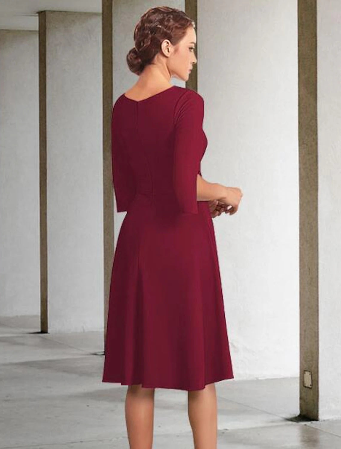 Close-up of the jewel neck and pleated details on the chiffon dress.