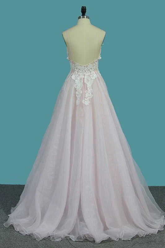 A-line deep V-neck prom dress with spaghetti straps and floral appliques.