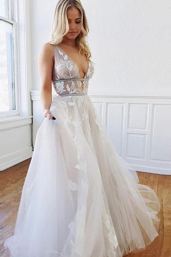 Elegant A-line white wedding dress with deep V-neck, backless design, and delicate appliques.