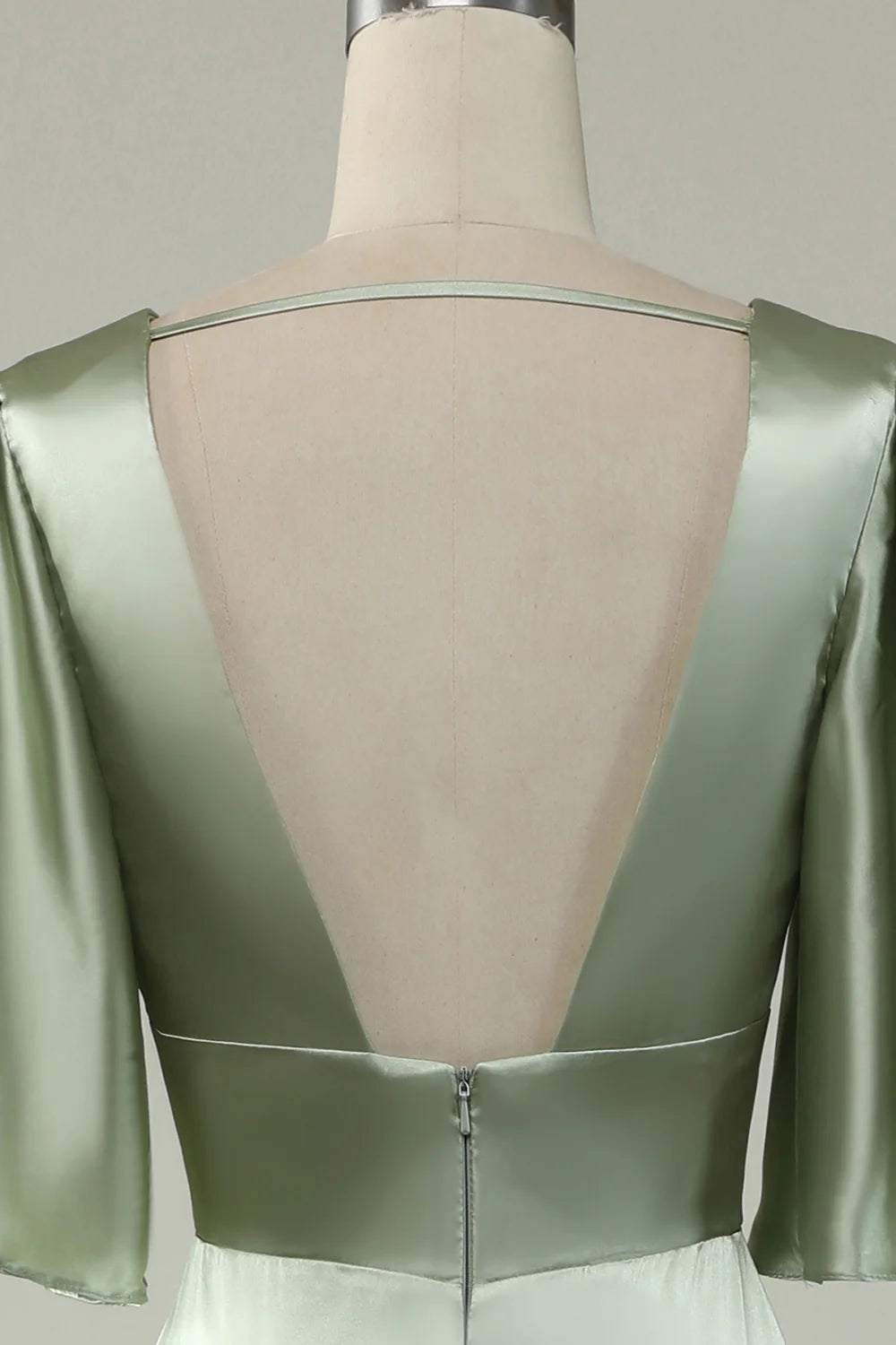 Model posing in an elegant light green satin deep V-neck long dress.