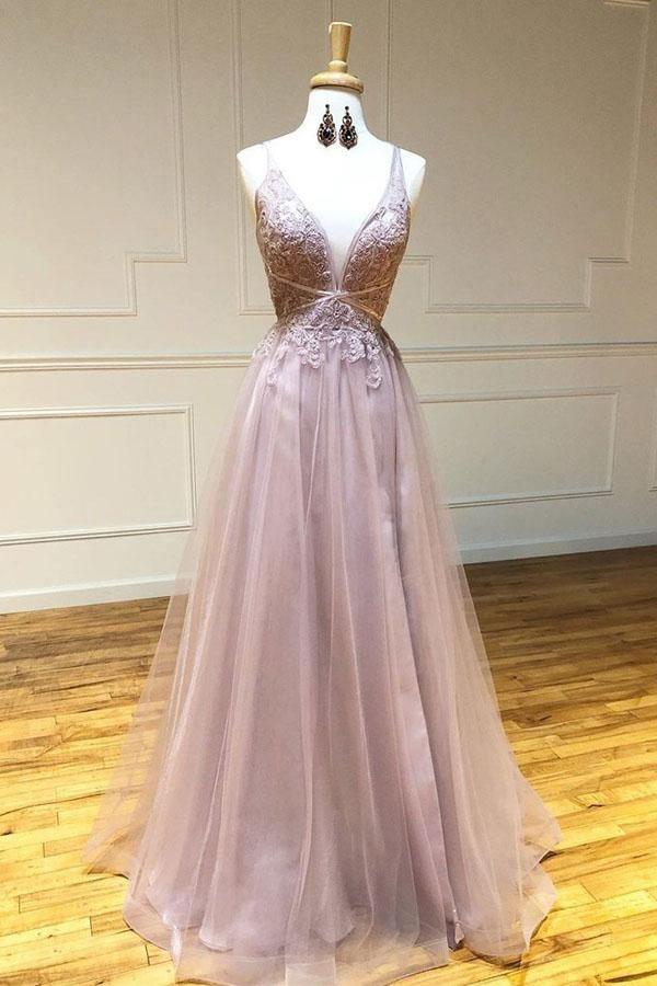 Woman wearing an A-line deep V-neck long sleeve tulle prom dress with appliques.