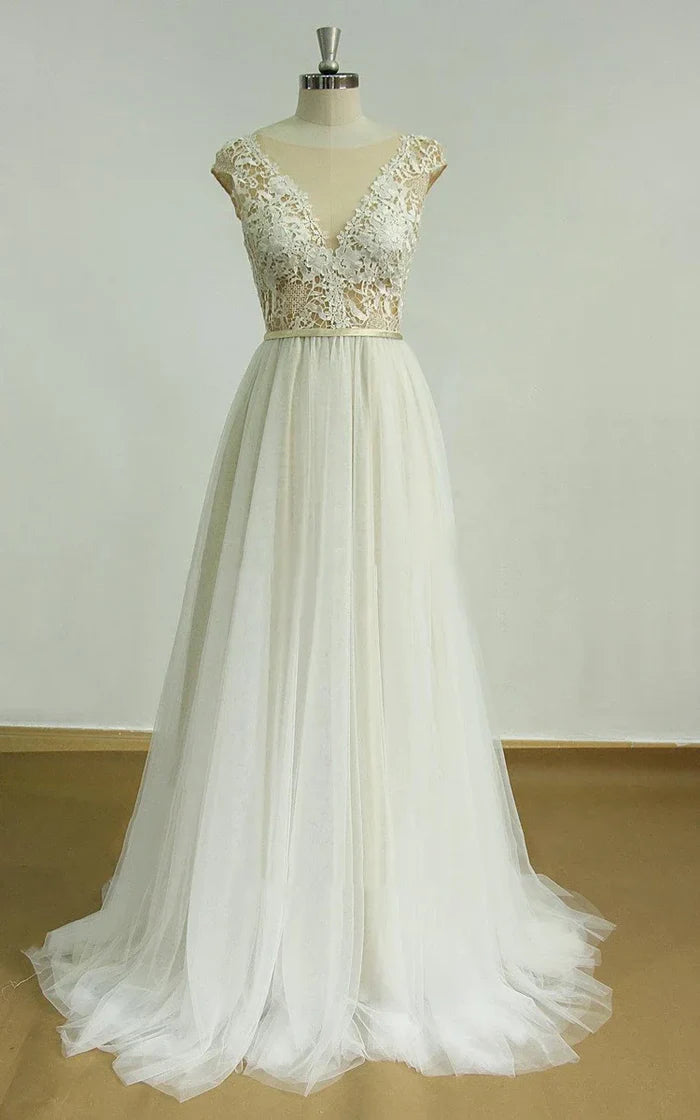 Model wearing an elegant white deep V-neck tulle lace wedding dress with an open back.