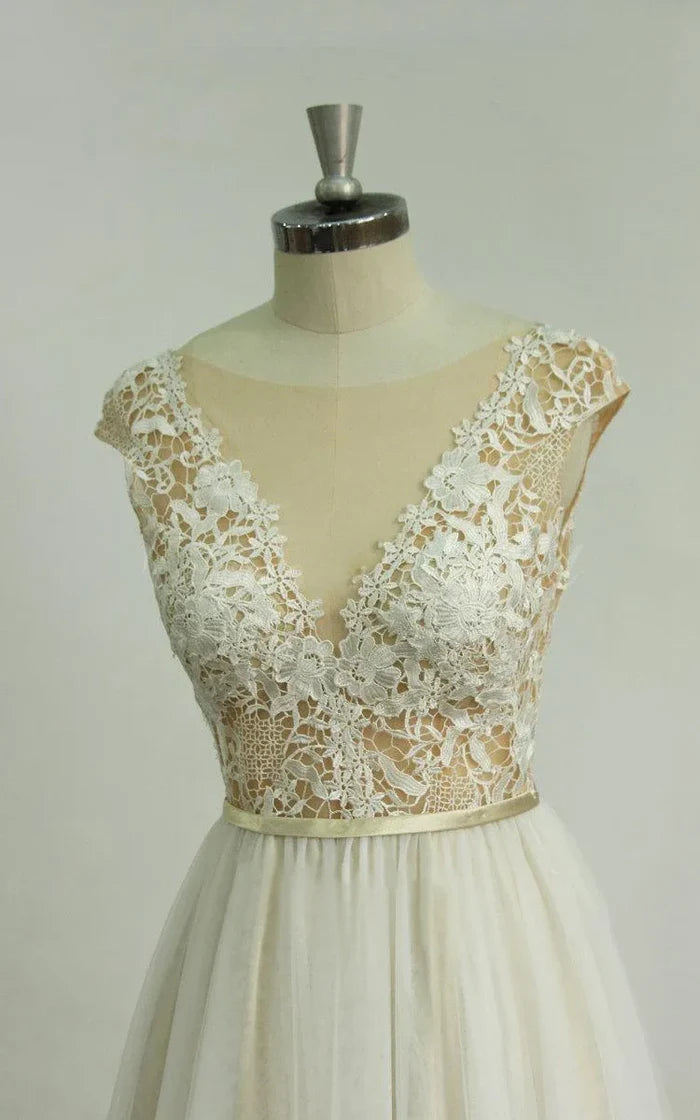Side profile of a white deep V-neck tulle lace wedding dress with a flowing skirt.