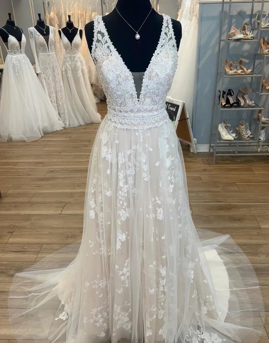 Champagne A-line plus size wedding dress with deep V-neck and delicate appliques.