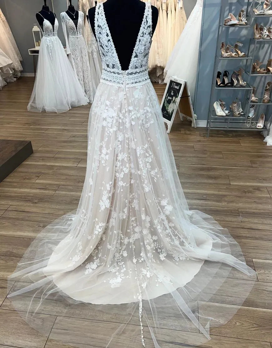 Full length view of a champagne A-line wedding gown with intricate appliques.