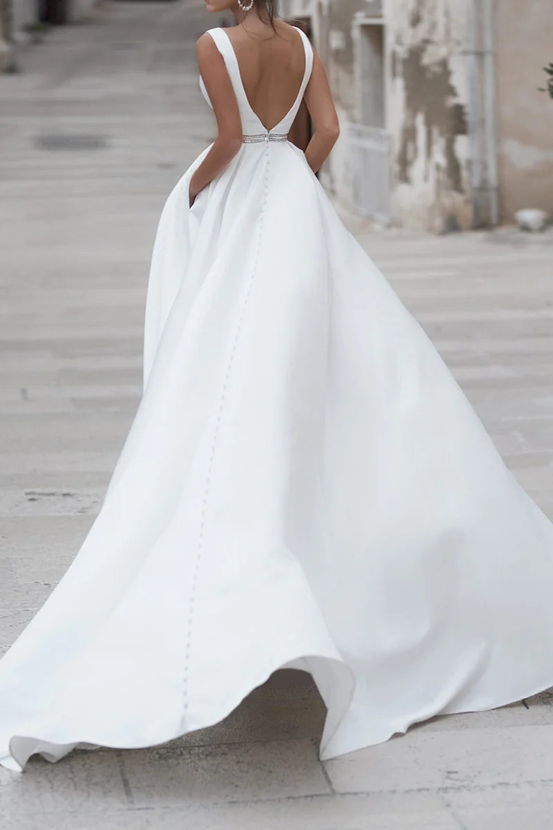 Side view of an A-line deep V-neck satin bridal gown with a simple train.
