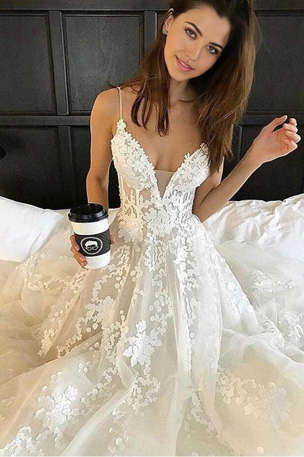 Bridal gown featuring spaghetti straps and a flowing skirt.