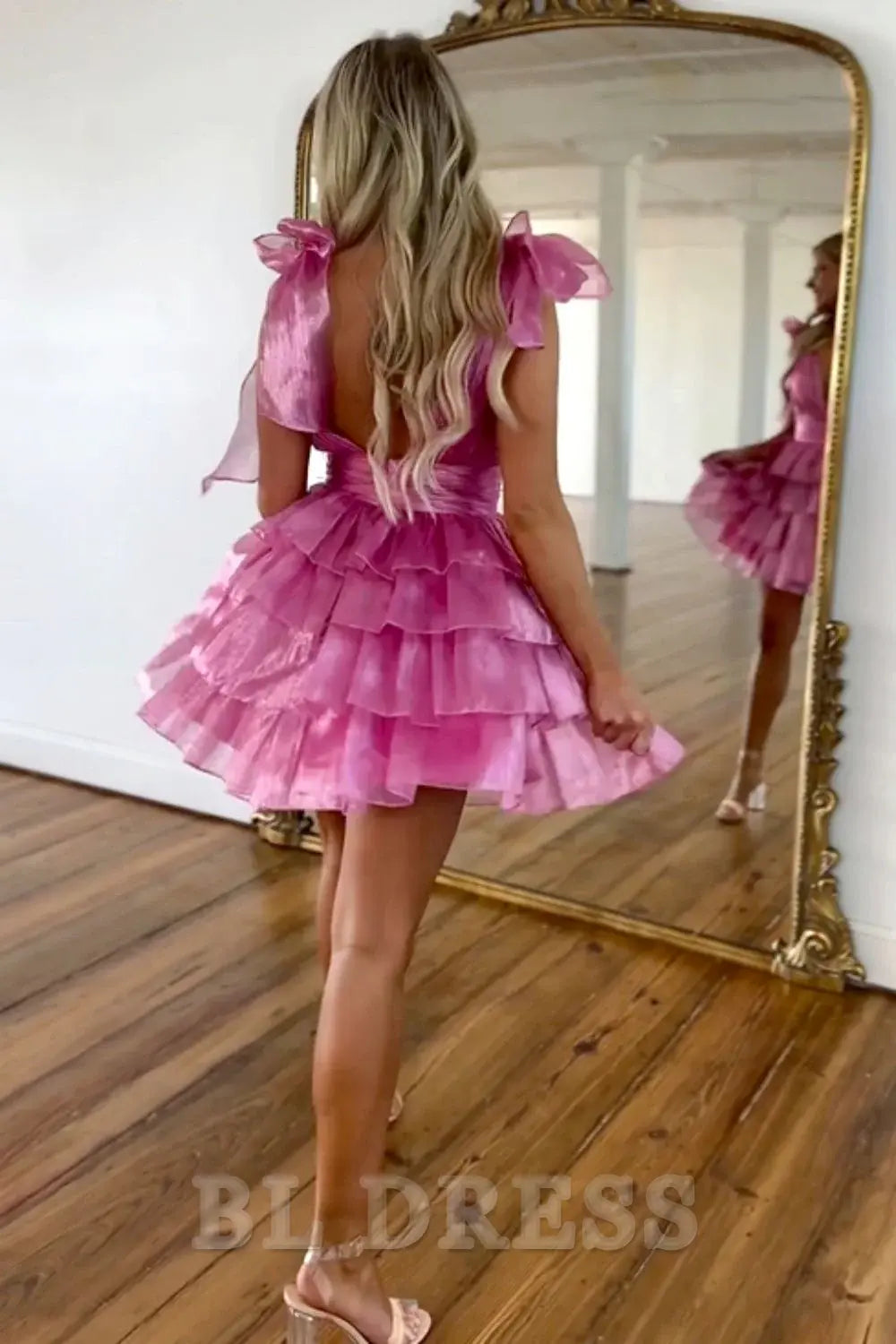 Model in an elegant A-line deep V-neck short satin dress, side profile.