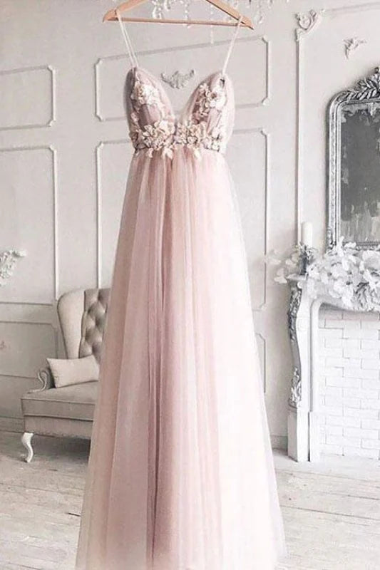Model wearing an elegant A-line prom dress with spaghetti straps and deep V-neck.