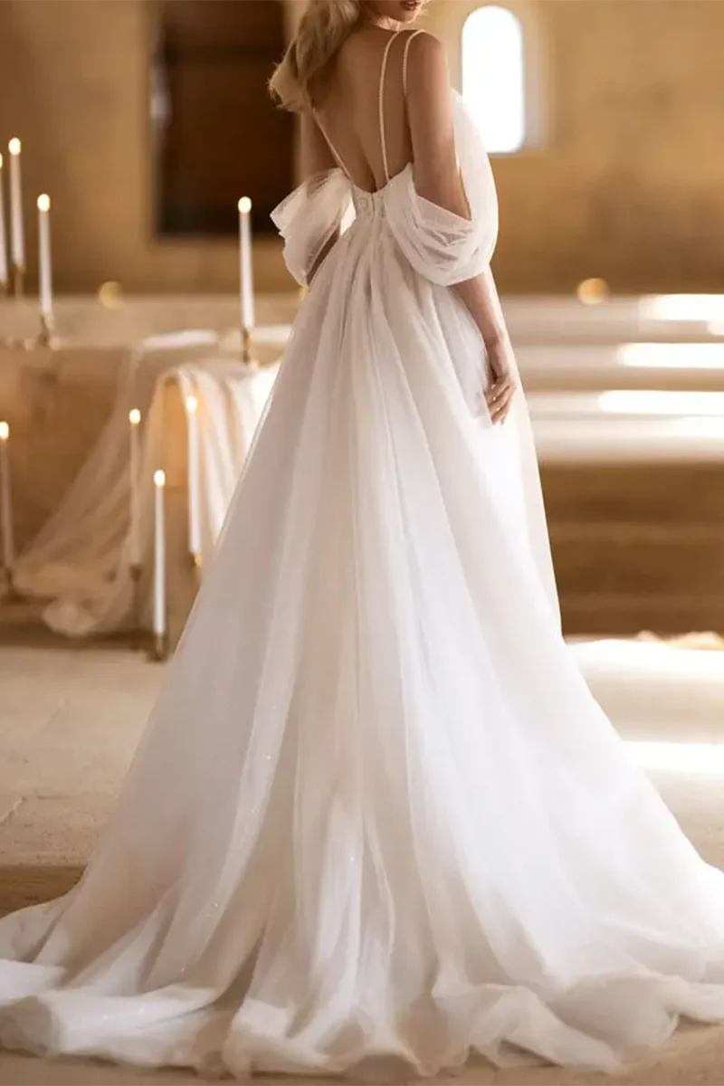 Close-up of the deep V-neckline and delicate tulle fabric on a wedding dress.