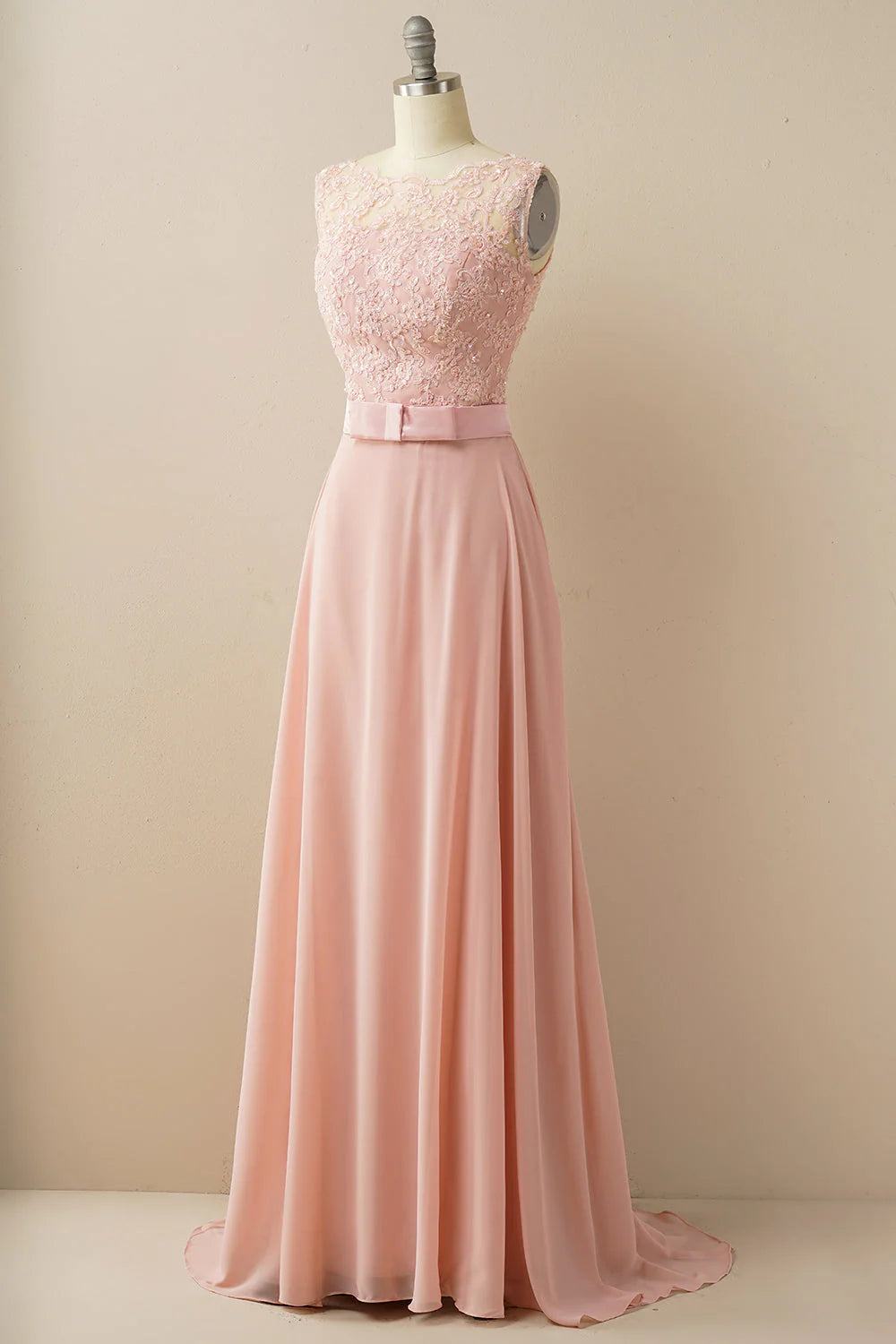 Model wearing an A-line empire illusion neck sleeveless floor-length evening gown with beaded lace appliques.