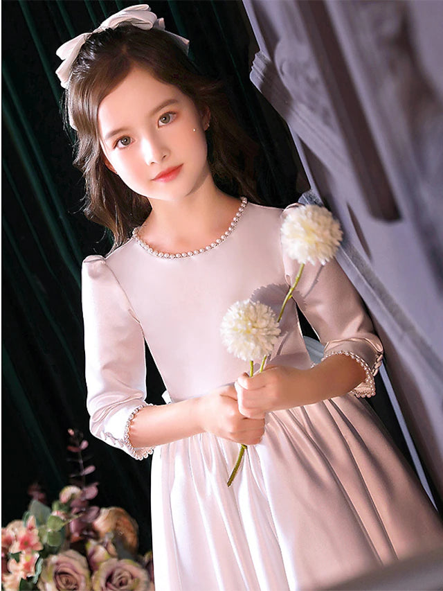 Back view of a girl in an A-line satin dress, suitable for First Communion.