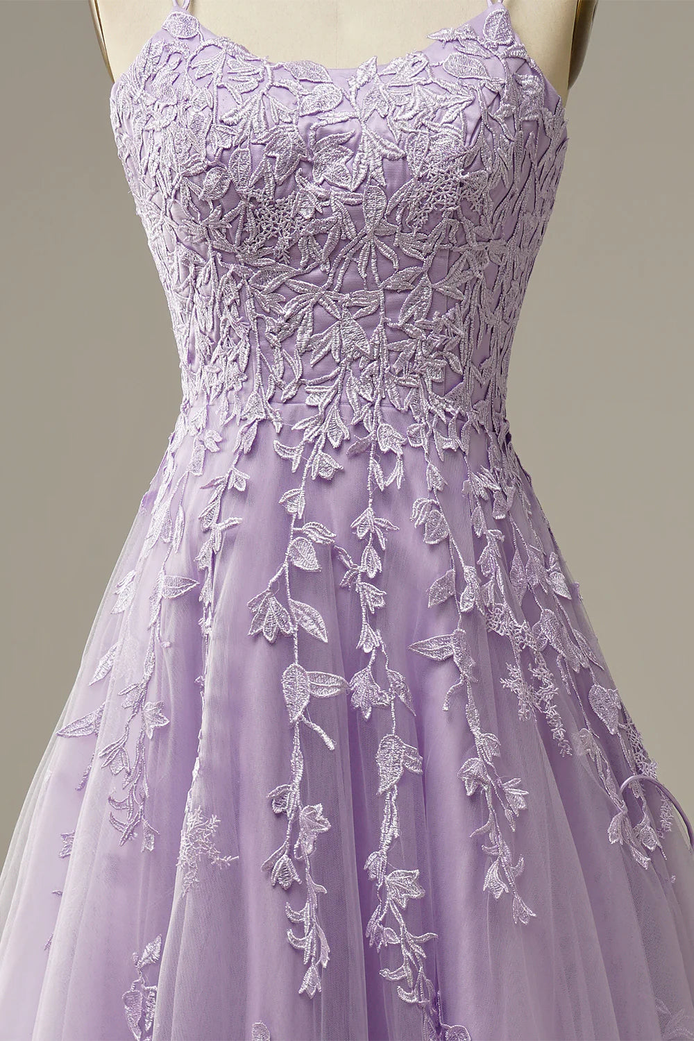 Close-up of floral appliques on a purple tulle prom dress.