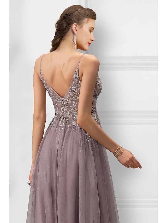 Close-up of floral embroidery and thigh-high slit on a tulle prom dress.